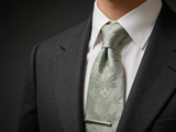 The Highland Thistle Silk Tie worn in a four-in-hand knot with a white collar and charcoal suit