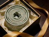 The Highland Thistle Silk Tie rolled in a gift box, close detail of the silk weave