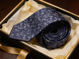 The Chelsea Vine Silk Tie rolled in a gift box, close detail of the silk weave