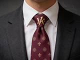 The Kingsway Heraldic Silk Tie worn in a four-in-hand knot with a white collar and charcoal suit