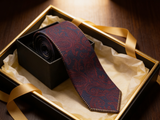 The Heritage Paisley Silk Tie rolled in a gift box, close detail of the silk weave