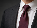 The Knightsbridge Navy & Burgundy Lattice Tie worn in a four-in-hand knot with a white collar and charcoal suit