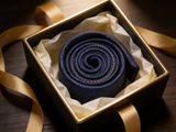 The Regent Midnight Paisley Tie rolled in a gift box, close detail of the silk weave