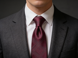 The Sovereign Geometric Silk Tie worn in a four-in-hand knot with a white collar and charcoal suit