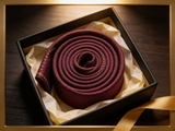The Knightsbridge Navy & Burgundy Lattice Tie rolled in a gift box, close detail of the silk weave