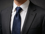 The Regent Midnight Paisley Tie worn in a four-in-hand knot with a white collar and charcoal suit