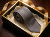 The Mayfair Lattice Silk Tie rolled in a gift box, close detail of the silk weave