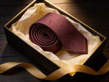 The Sovereign Geometric Silk Tie rolled in a gift box, close detail of the silk weave