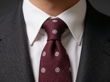 The Mayfair Burgundy Diamond Tie worn in a four-in-hand knot with a white collar and charcoal suit