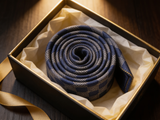 The Regent Silver Geometric Tie rolled in a gift box, close detail of the silk weave
