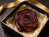 The Highgrove Burgundy Floral Tie rolled in a gift box, close detail of the silk weave