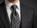 The Shard Geometric Prism Tie worn in a four-in-hand knot with a white collar and charcoal suit