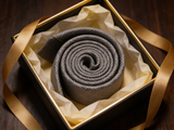 The Regent Geometric Diamond Tie rolled in a gift box, close detail of the silk weave