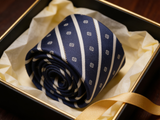 The Mayfair Club Stripe Tie rolled in a gift box, close detail of the silk weave