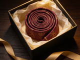 The Sovereign Crown & Crest Tie rolled in a gift box, close detail of the silk weave