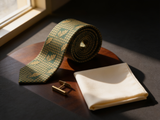 Sherwood Houndstooth Oak Tie coiled on dark walnut with a pocket square and brass collar bar