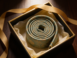 Sage Brocade Floral Tie rolled in a gift box, close detail of the silk weave