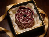 Royal Crown Burgundy Tie rolled in a gift box, close detail of the silk weave