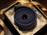 Glenurquhart Gold Windowpane Tie rolled in a gift box, close detail of the silk weave