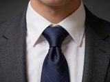 Glenurquhart Gold Windowpane Tie worn in a four-in-hand knot with a white collar and charcoal suit